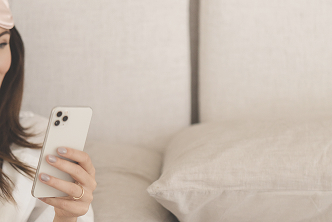 Woman typing on white iPhone in a cosy neutral environment