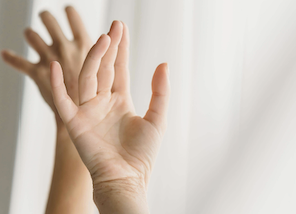 two hands moving elegantly free with a white curtain in the background
